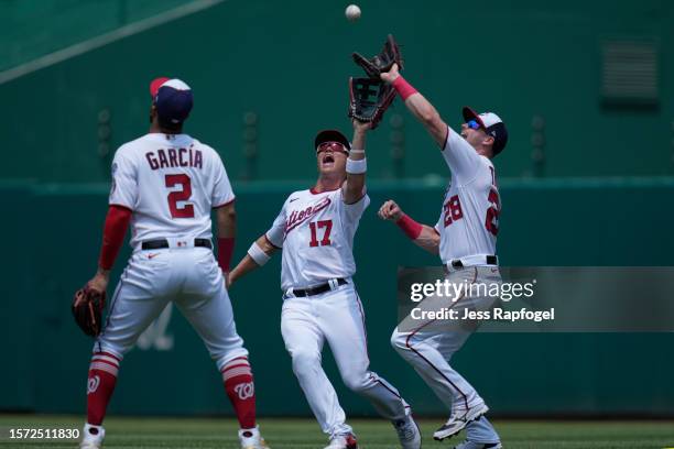 Alex Call of the Washington Nationals and Lane Thomas collide as they reach for a fly ball hit by Austin Wynns of the Colorado Rockies during the...