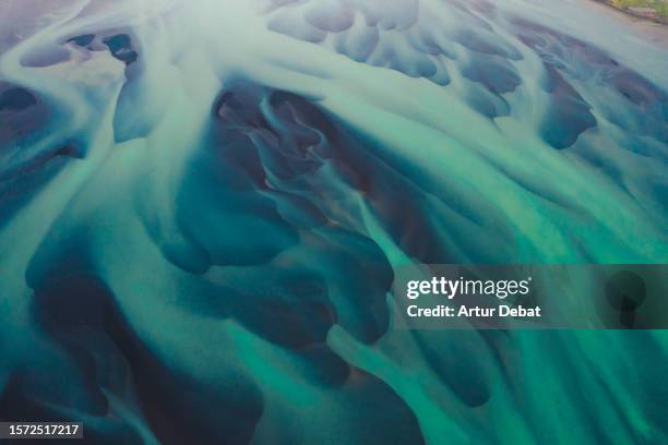 aerial view of the abstract shapes in a blue glacier river in iceland. - earth ice melt stock pictures, royalty-free photos & images