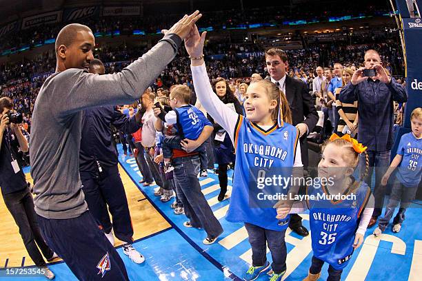 Eric Maynor of the Oklahoma City Thunder greets young fans before a game against the Utah Jazz on November 30, 2012 at the Chesapeake Energy Arena in...