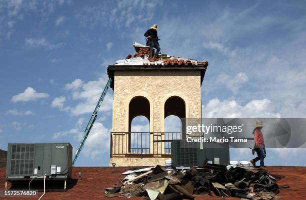 People work on the bell tower of a church amid the city's worst heat wave on record on July 26, 2023 in Phoenix, Arizona. While Phoenix endures...