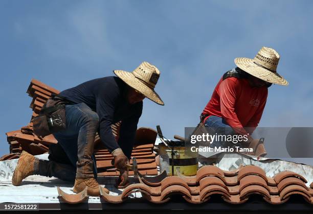 People work on the roof of a church amid the city's worst heat wave on record on July 26, 2023 in Phoenix, Arizona. While Phoenix endures periods of...