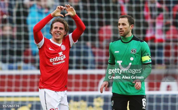 Nicolai Mueller of Mainz celebrates his team's first goal as he runs past Steven Cherundolo of Hannover during the Bundesliga match between 1. FSV...