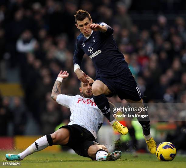 Gareth Bale of Tottenham is tackled by Ashkan Dejagah of Fulham during the Barclays Premier League match between Fulham and Tottenham Hotspur at...