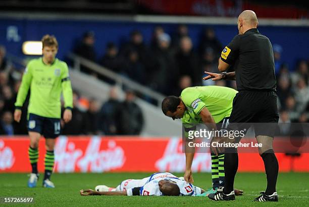 Stephane Mbia of Queens Park Rangers lies injured on the pitch during the Barclays Premier League match between Queens Park Rangers and Aston Villa...