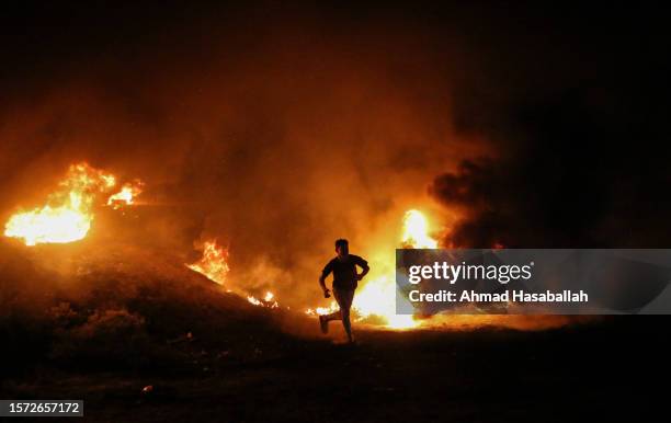 Palestinians burn tires along the border fence with Israel, east of Gaza City in protest against the Israeli occupation forces storming Al-Aqsa...