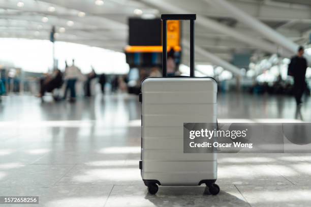 a suitcase in the airport under sunlight - travel essentials stock pictures, royalty-free photos & images