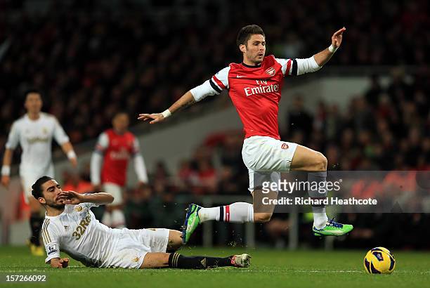 Olivier Giroud of Arsenal goes down when challenged by Chico of Swansea during the Barclays Premier League match between Arsenal and Swansea City at...