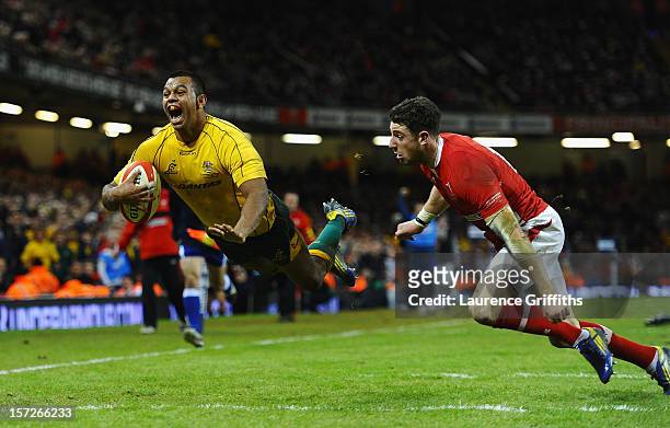 Kurtley Beale of Australia scores a last minute try to win the match under pressure from Alex Cuthbert of Wales during the International match...