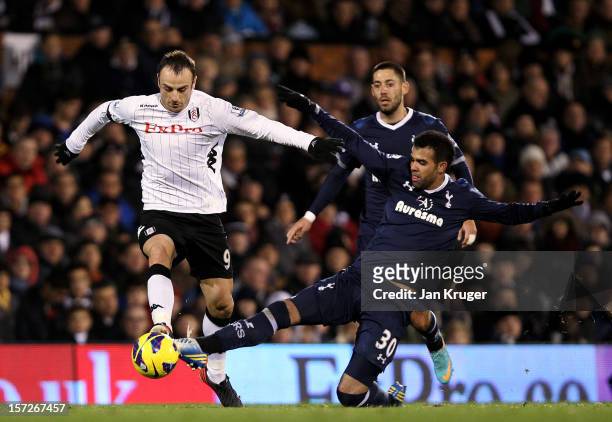Dimitar Berbatov of Fulham battles with Sandro of Tottenham during the Barclays Premier League match between Fulham and Tottenham Hotspur at Craven...