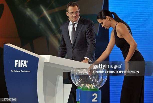 Brazilian model Adriana Lima drawa a ball as FIFA secretary general Jerome Valcke looks on during the draw for next June's Confederations Cup Brazil...