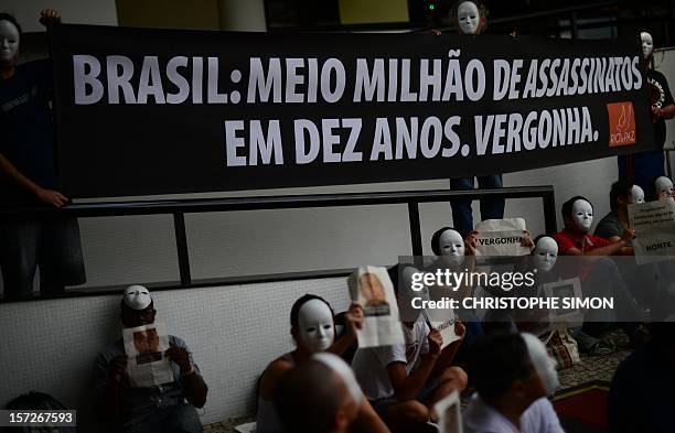 Members of the anti violence group Paz de Rio protest against the increase of the murder rate in Brazil, during the draw for next June's...