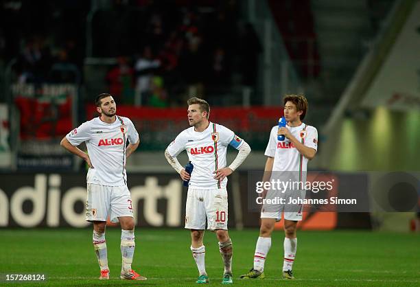 Sascha Moelders, Daniel Baier ad Ja-Cheol Koo of Augsburg look dejected after the Bundesliga match between FC Augsburg and SC Freiburg at SGL Arena...