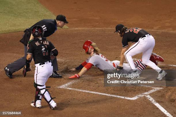 Brendan Donovan of the St. Louis Cardinals scores on a wild pitch ahead of pitcher Zac Gallen of the Arizona Diamondbacks during the third inning of...