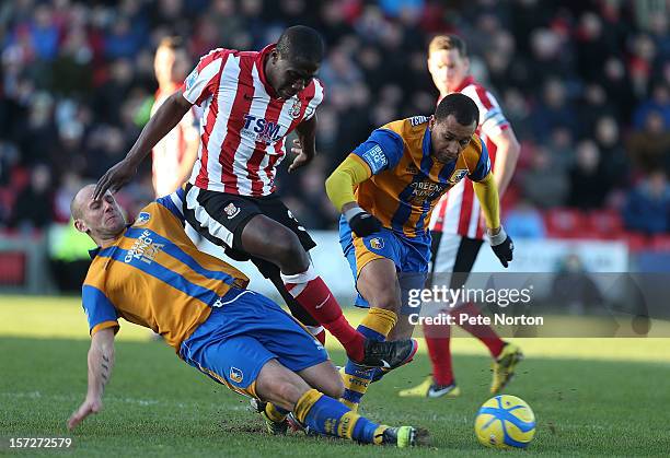 Mamadou Fofana of Lincoln City is tackled by Adam Murray of Mansfield Town as Matt Green looks on during the FA Cup with Budweiser Second Round match...