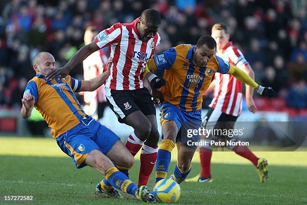 Mamadou Fofana of Lincoln City is tackled by Adam Murray of Mansfield Town as Matt Green looks on during the FA Cup with Budweiser Second Round match...