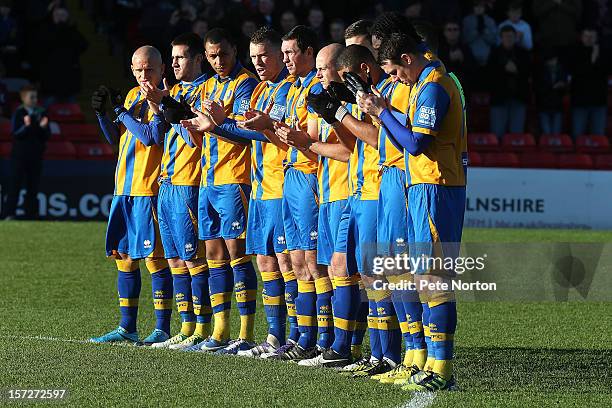 Mansfield Town players observe a minutes applause in memory of former Lincoln City player Bert Linnecor prior to the FA Cup with Budweiser Second...