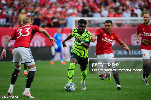 Bukayo Saka of Arsenal is defended by Casemiro of Manchester United during a game between Arsenal and Manchester United at MetLife Stadium on July...
