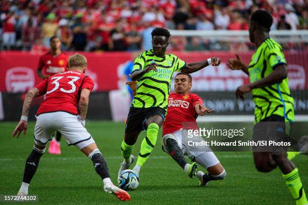 Bukayo Saka of Arsenal is defended by Casemiro of Manchester United during a game between Arsenal and Manchester United at MetLife Stadium on July...