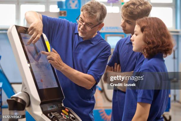 profesor explicando a los alumnos máquina cnc en taller - aprendiz fotografías e imágenes de stock