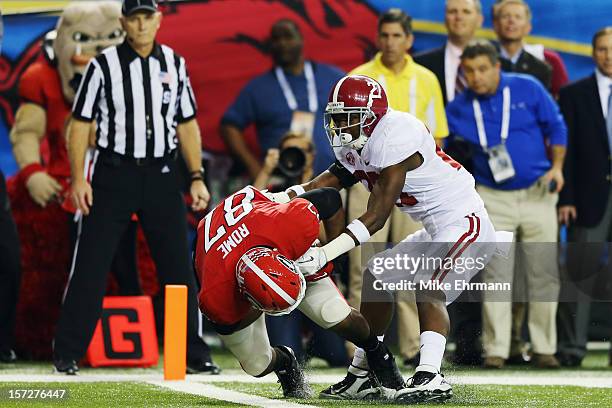 Tight end Jay Rome of the Georgia Bulldogs falls into the end zone for a touchdown as defensive back Nick Perry of the Alabama Crimson Tide tries to...