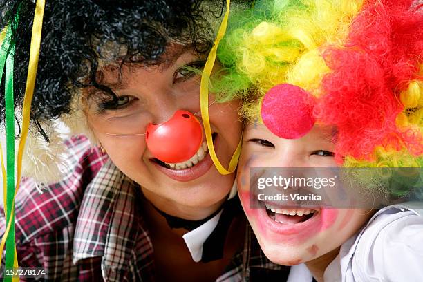 mother and child dressed up as funny clowns - circus stockfoto's en -beelden