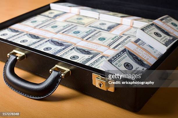 attache lleno de dinero sobre la mesa - money laundering fotografías e imágenes de stock