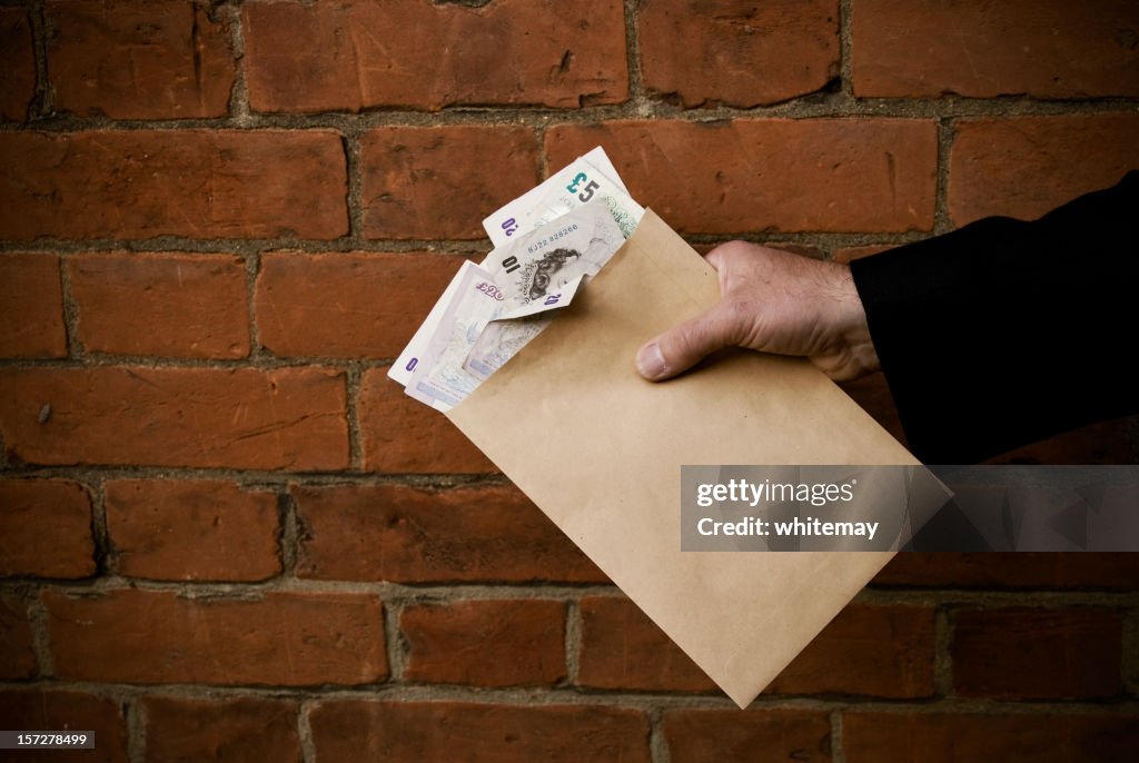 Hand holding envelope and bank notes