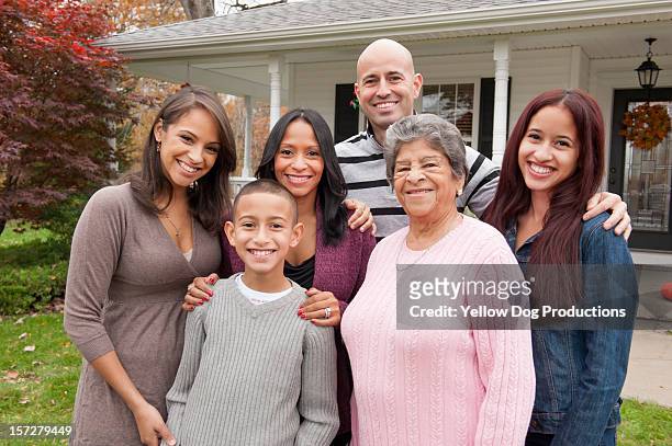 portrait of a family smiling in front of home - adolescent daughter mother portrait stock-fotos und bilder