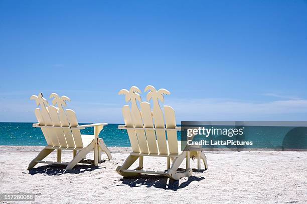 posterior de color blanco sillas de madera en la arena con vista al mar - st petersburg florida fotografías e imágenes de stock