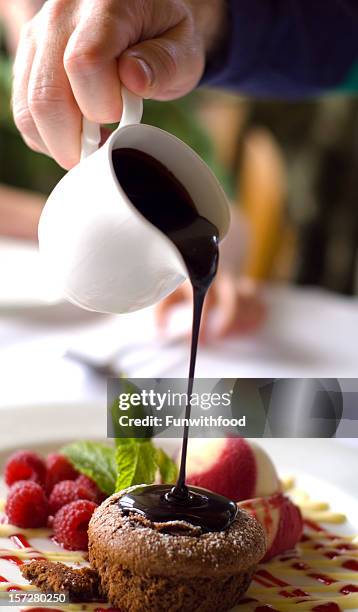 chocolate mousse soufflé kuchen & eis dessert eingießen toffee-sauce - fondant cakes stock-fotos und bilder