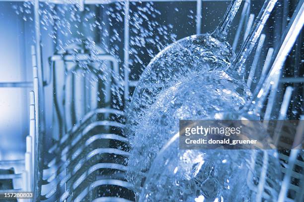interior of operating dishwasher with water splashing on wine glasses - dishwasher stock pictures, royalty-free photos & images