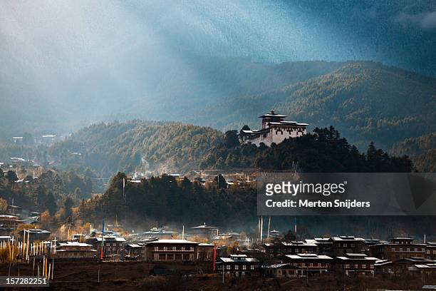 dramatic sunrays over jakar dzong - bhutan stock pictures, royalty-free photos & images