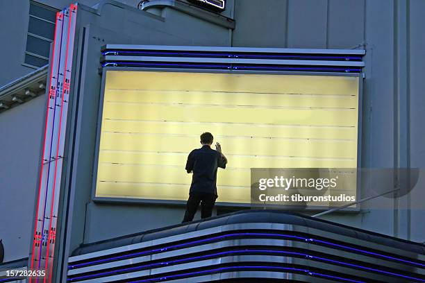 now showing! man changing sign - luifel theater stockfoto's en -beelden