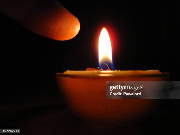 finger pointing at a candle flame - burning the candle at both ends stock pictures, royalty-free photos & images