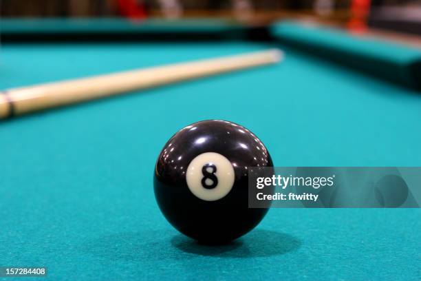 close up of 8 ball on green felted pool table - pool cue sport stock pictures, royalty-free photos & images