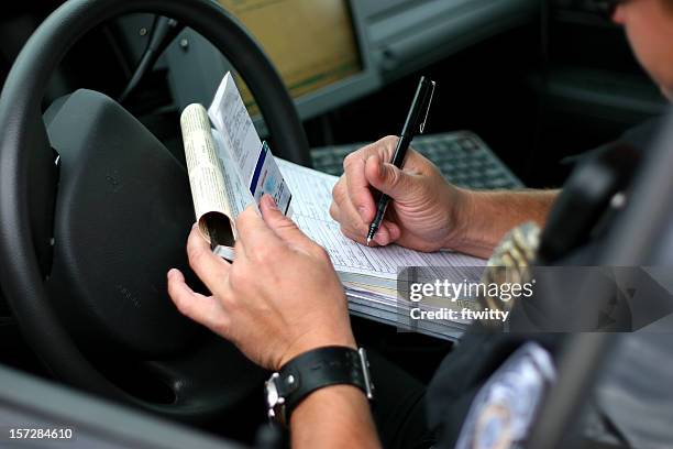 police officer writing ticket 2 - verkeerspolitie stockfoto's en -beelden