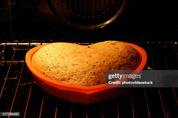 love cake rising in the oven (4) - rijzen stockfoto's en -beelden