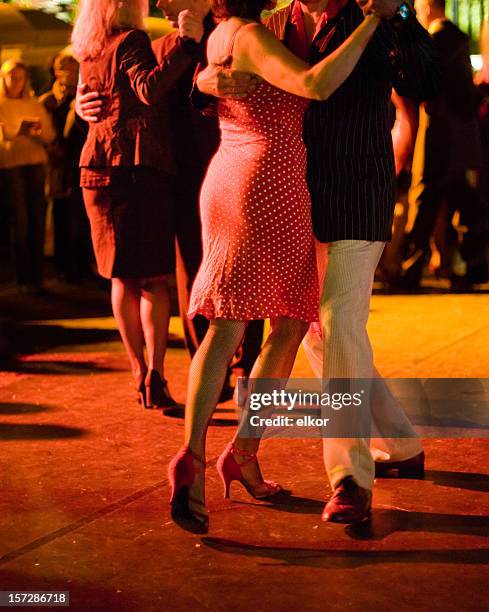 couples dancing argentine tango outdoors at night, focus on legs. - ballroom stockfoto's en -beelden