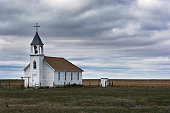 Old White Wooden Church in Rural Field Scene with Storm