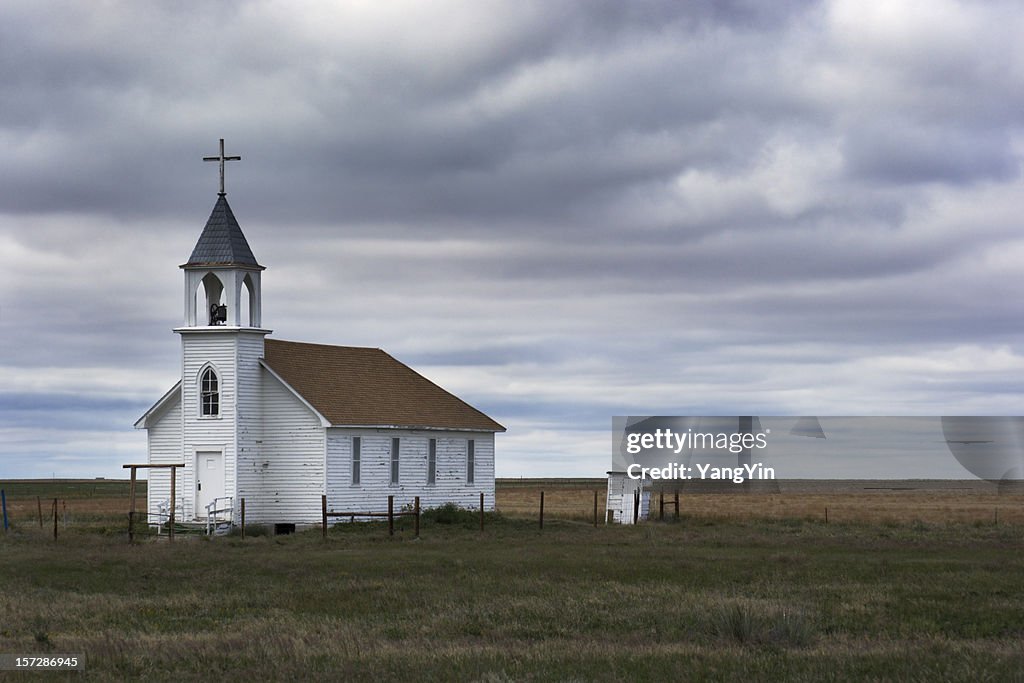 Old White Wooden Church in Rural Field Scene with Storm