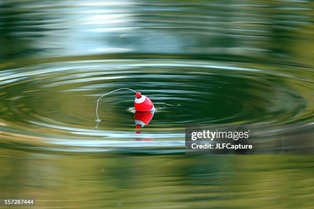 just fishing - cork floating on calm lake - jig stock pictures, royalty-free photos & images