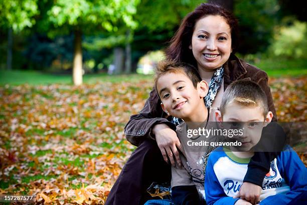 autumn day, hispanic family, single mom with two sons, copyspace - family with two children stockfoto's en -beelden