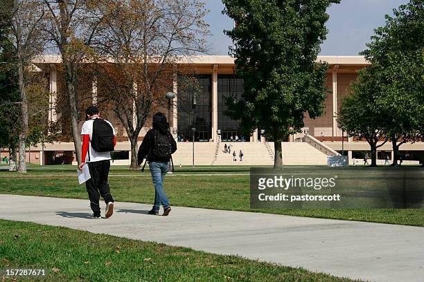 class walk two students male and female on college campus - northridge stock pictures, royalty-free photos & images