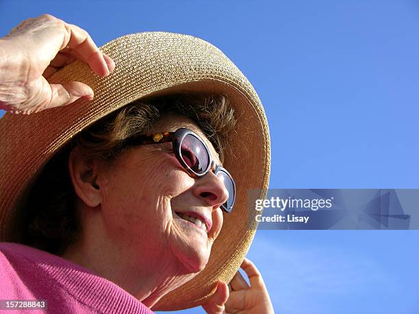 femme à la recherche au coucher du soleil - chapeau de soleil photos et images de collection