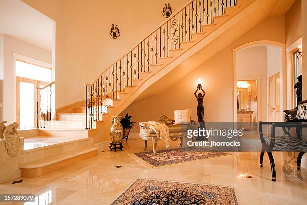 posh entry with spiral staircase - luxury mansion interior stock pictures, royalty-free photos & images