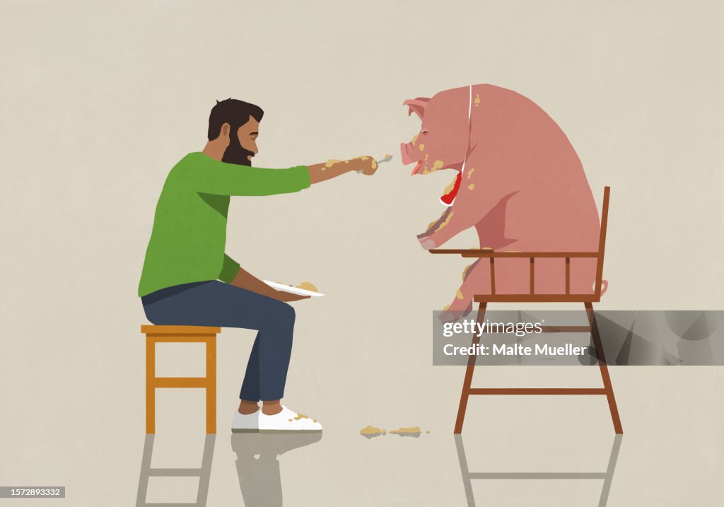 Man feeding messy pet pig in high chair