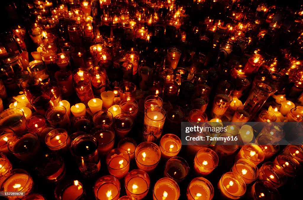 A close-up of multiple candles in a vigil