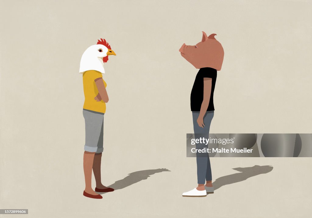 Confrontational couple in pig and chicken heads standing face to face