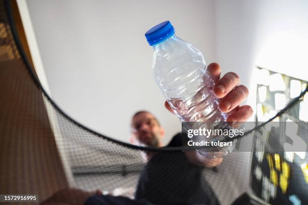 man placing bottle in recycling bin - white garbage can stock pictures, royalty-free photos & images