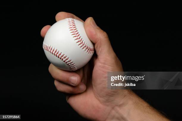 close-up of man's hand griping a baseball - baseball pitcher close up stock pictures, royalty-free photos & images